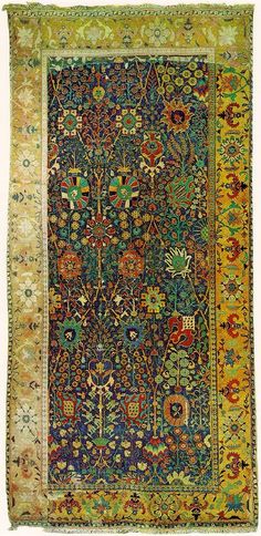 an antique persian rug with colorful floral designs on blue and yellow ground, possibly from the late 19th century