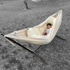 a baby is laying in a hammock on the ground