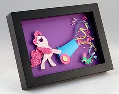 a shadow box with a cut out of a pink pony and some decorations in it