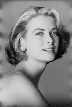 an old black and white photo of a woman with short hair smiling at the camera