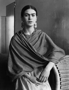 an old photo of a woman sitting in a chair with a shawl over her shoulders