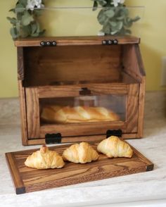 two croissants sitting on a cutting board in front of a wooden box