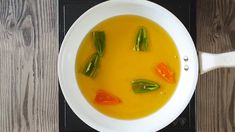 a white bowl filled with soup on top of a stove