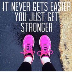 a person with pink shoes standing in front of a street sign that says, it never gets easier you just get stronger