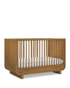 a wooden crib with white sheets on the bottom and sides, in front of a white background