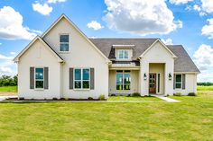 a large white house sitting on top of a lush green field