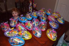 a young boy sitting at a table with many plastic toys in it's bags