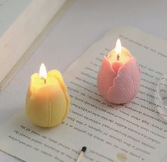 two candles sitting on top of an open book