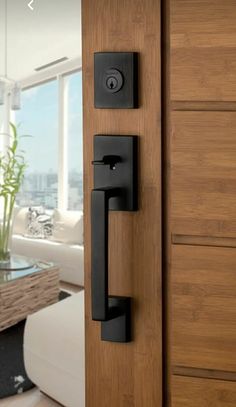 an open door with black handles in front of a living room and dining room area