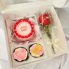 a box with some cupcakes and flowers in it