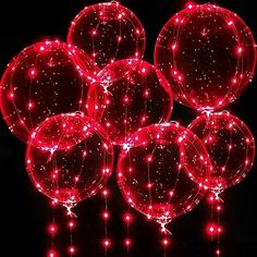 several red lighted balloons are in the dark