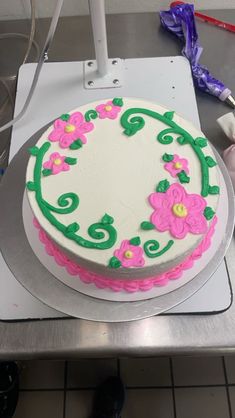 a decorated cake sitting on top of a metal counter next to a pair of scissors