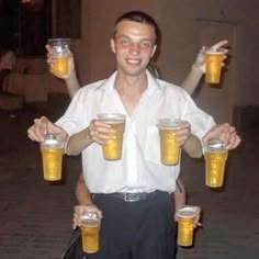 a man is holding two mugs of beer