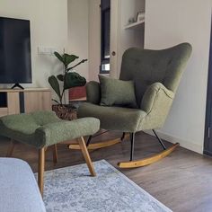 a living room with a rocking chair and footstool in front of a flat screen tv