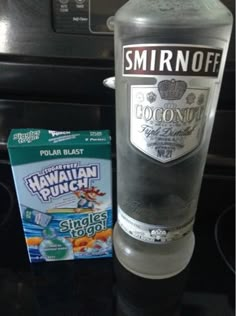 a bottle of water sitting on top of a stove next to a package of snacks