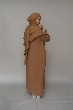 Introducing the Avalom Prayer Gown Umrah Abaya Dress in Brown by Annah Hariri, the perfect addition to your modest wardrobe. This elegant one-piece abaya dress is made from non-wrinkling fabric, ensuring that you always look put-together without the hassle of ironing.Featuring a classic A-cut design, this abaya dress offers ample coverage, making it suitable for any prayer occasion. It also comes with pockets, making it functional and convenient for carrying your essentials. The beautiful sleeve Umrah Abaya, Modest Wardrobe, Abaya Designs, Abaya Dress, Modest Wear, Niqab, Cut Design, Wrinkle Free, Color Khaki