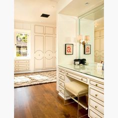 a bedroom with a vanity, mirror and dressing table in it's center area