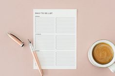 a cup of coffee next to a notepad with the words daily to do list on it