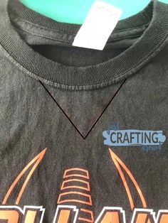 a gray shirt with an orange and black design on the front that says crafting supply