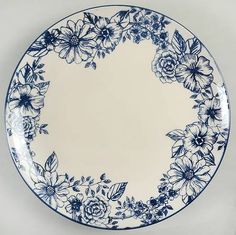 a blue and white plate with flowers on the rim is sitting on a table top