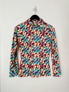 > lovely 1970s button down blouse > long sleeve > pointed collar > bright print of woman with umbrella > colors include brown, turquoise. purple. beige  Label: No label or maker  Material: Polyester SIZE: Fits like a women's US size Small  --✂ Please measure yourself prior to purchase to ensure a good fit MEASUREMENTS in inches (measured while laying flat) Shoulder (seam to seam): 14.5" Bust (pit to pit): 16.75" Length (top of back collar to bottom hem): 25" Sleeve: 22" In good vintage condition; shows gentle surface wear characteristic of age and previous use. Some fabric pilling, please see last photo.  Our collection is stored safely in our smoke-free studio and everything is ready to ship! Woman With Umbrella, Fabric Pilling, Peter Pan Collar Blouse, Pan Collar, Peter Pan Collar, Printed Blouse, Peter Pan, Womens Clothing Tops, 1970s