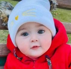 a baby wearing a red jacket and white hat with an animal ears on it's head