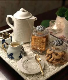 a tray filled with cookies and crackers on top of a table next to a tea pot