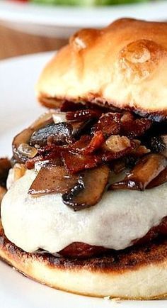 a close up of a sandwich on a plate with meat and mushrooms in the middle