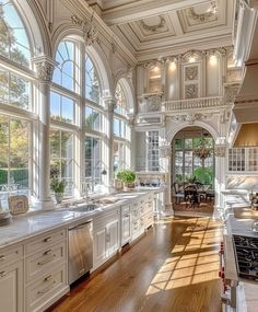 a large kitchen with lots of windows and white cabinets on both sides of the room