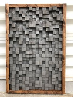 a wooden frame made out of square blocks on the side of a building with a white wall in the background