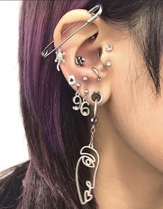 a close up of a person with ear piercings on their ears and behind the ear