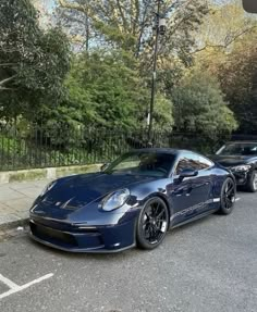 two blue sports cars parked next to each other