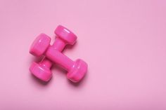 two pink dumbbells on a pink background