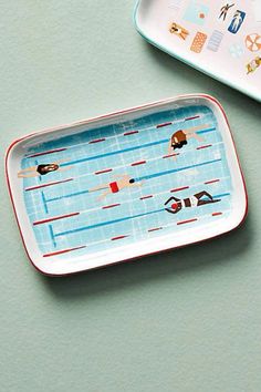 two plates with swimmers on them sitting next to each other in front of a tray