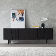 a black sideboard sitting on top of a white rug in front of a wall