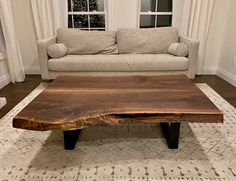 a living room with a couch, coffee table and window in the background at home