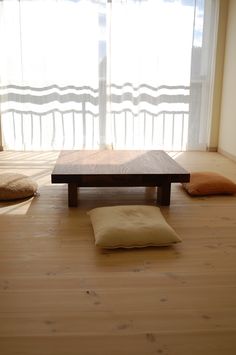 there is a dog bed on the floor in front of a window with sheer curtains