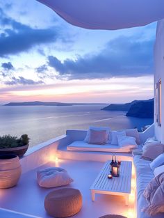 a white couch sitting on top of a roof next to a table with candles in front of it