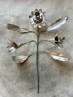 a flower made out of metal leaves and feathers