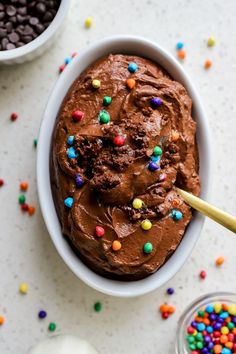 a bowl filled with chocolate ice cream surrounded by sprinkles