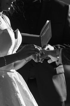 black and white photograph of a woman in a wedding dress holding an open ring box