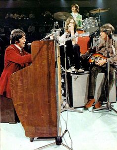 the rolling stones performing on stage with their guitars and drums in front of an audience