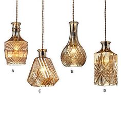 four glass vases hanging from a rope with lights on them and the names below