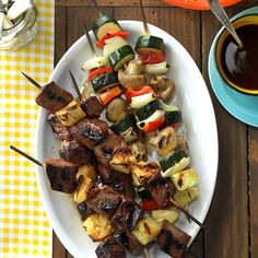 a white plate topped with meat and veggies next to a cup of coffee