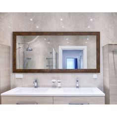 a bathroom with two sinks and a large mirror on the wall above it is also a walk in shower