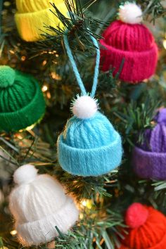 colorful knitted hats hanging from a christmas tree