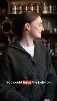 a woman standing in front of a shelf filled with jars