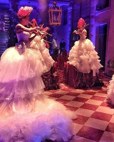 three mannequins dressed in white and pink tulle dresses with bows on their heads