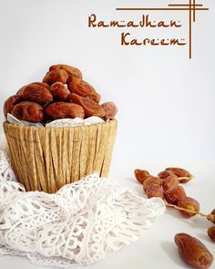 a basket filled with raisins on top of a white doily next to dates