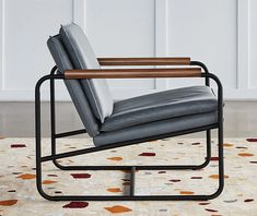 a gray leather chair sitting on top of a rug